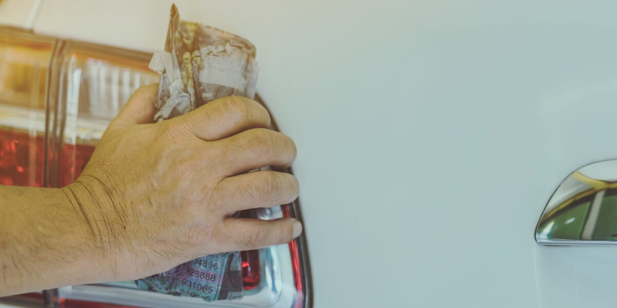 Domáci detailing automobilu v garáži s leštením karosérie a obnovou lesku laku pomocou autokozmetiky.